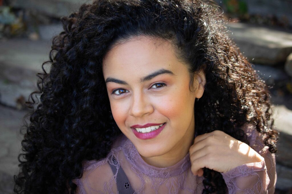 BigBong Photography: Woman with Voluminous Curls and Playful Makeup Flashes a Smile