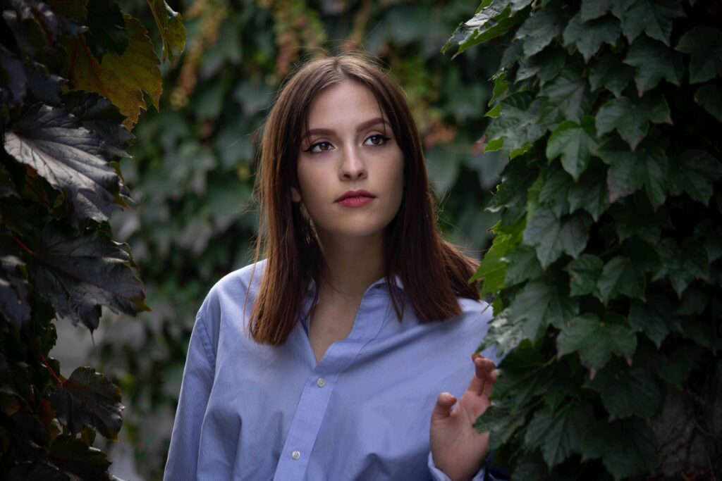 Portrait by BigBong: Young Woman in Blue Shirt Surrounded by Greenery
