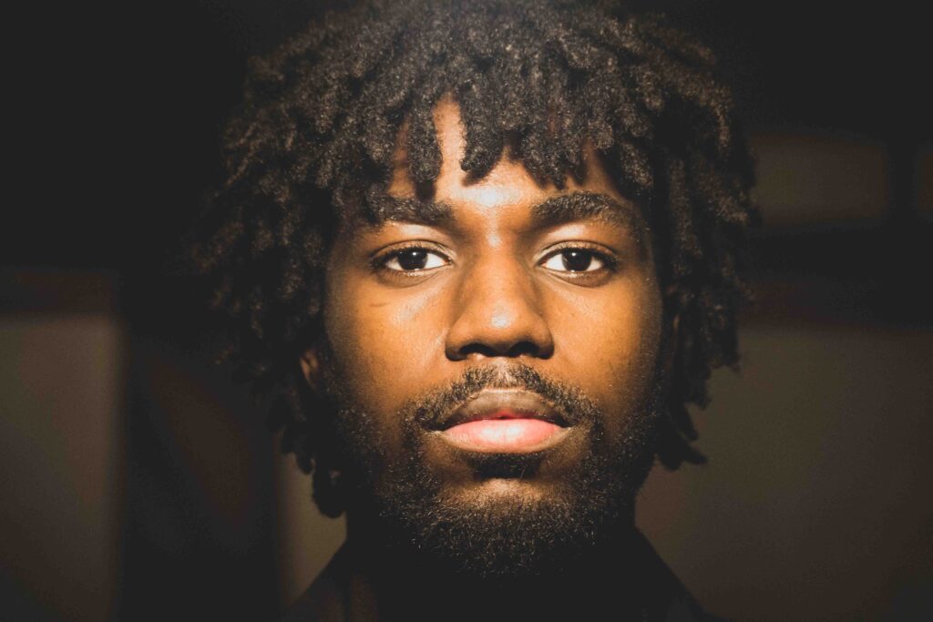 Portrait by BigBong: Young Black Man with Dreadlocks in Parking Lot