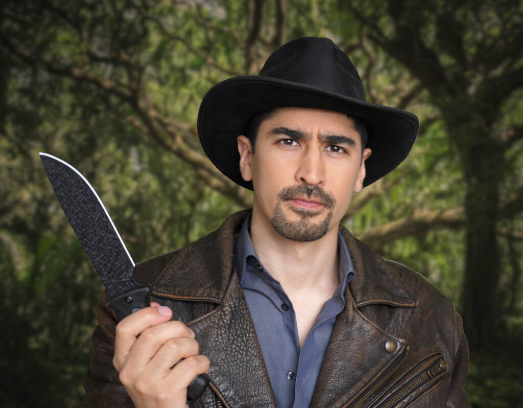Actor BigBong portraying Indiana Bong, wearing a hat, a leather jacket, and holding a knife in the jungle.